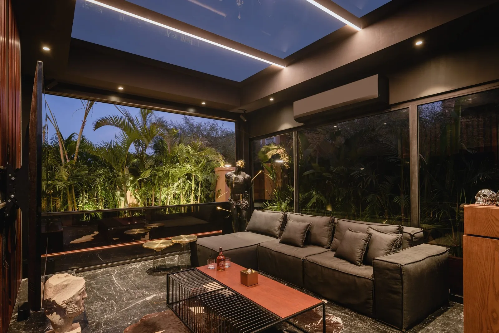 La Feuille Blanche — Glass lounge opening onto the garden at dusk