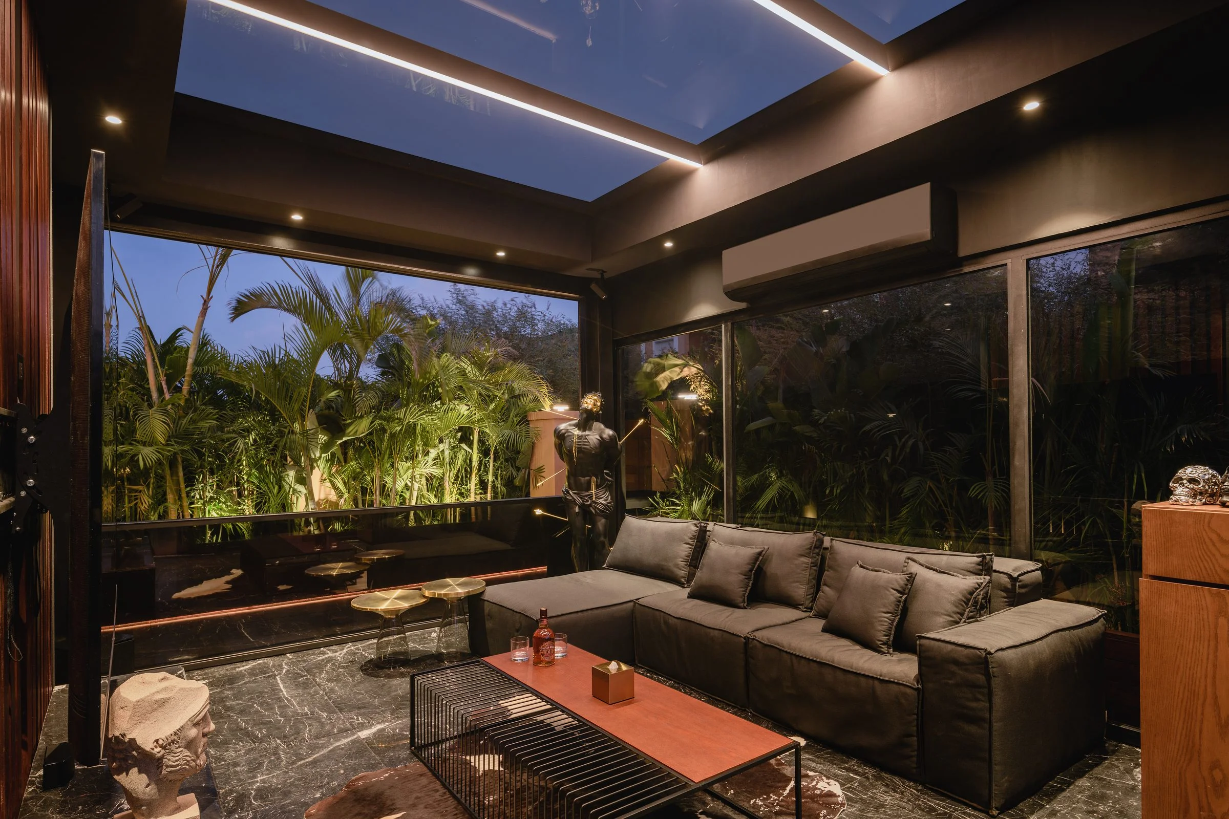 La Feuille Blanche — Glass lounge opening onto the garden at dusk