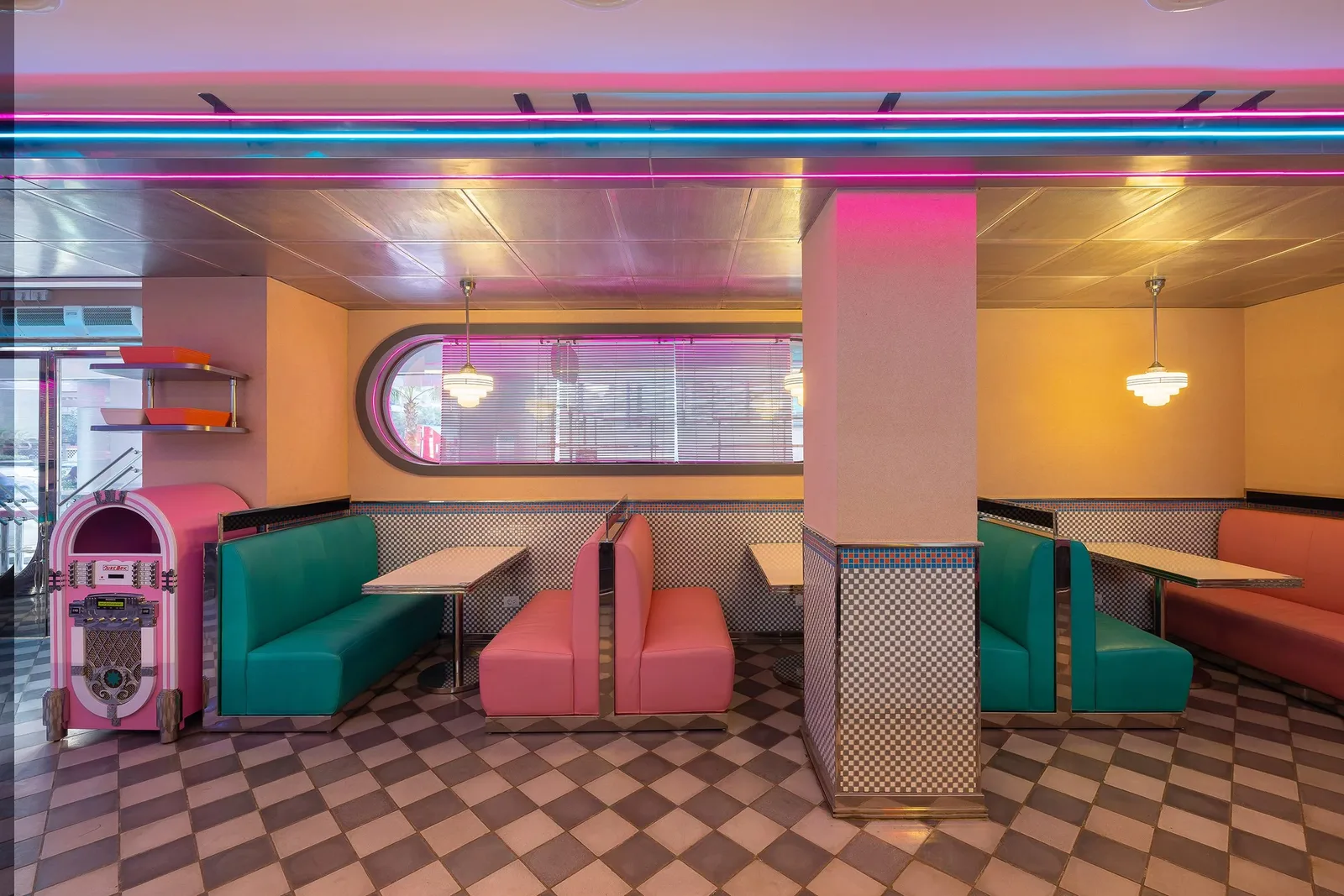 Pablo & Abdo — Green and strawberry-pink booths beneath porthole windows