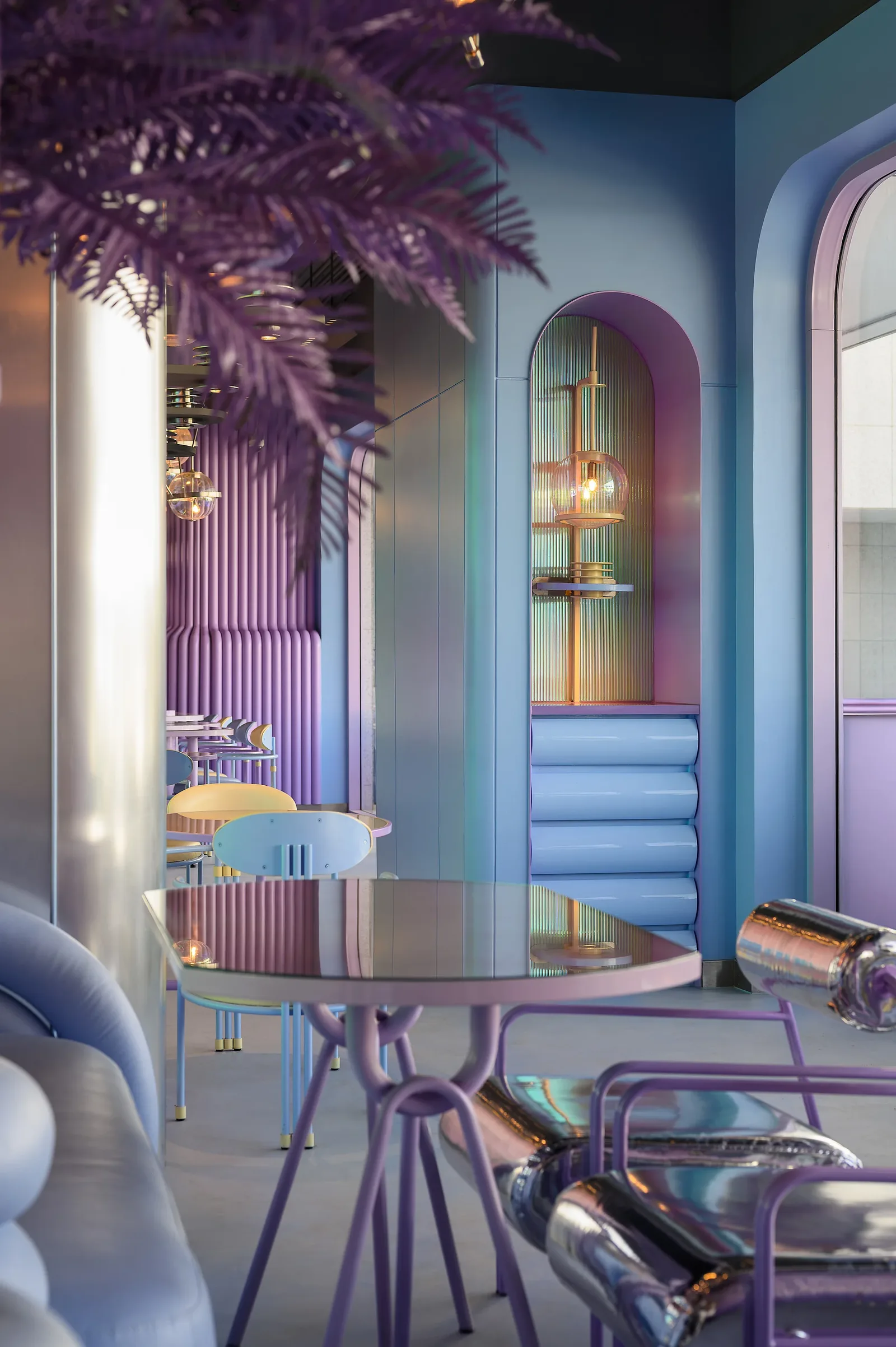 Talkback — Table beneath a violet palm with chrome chairs