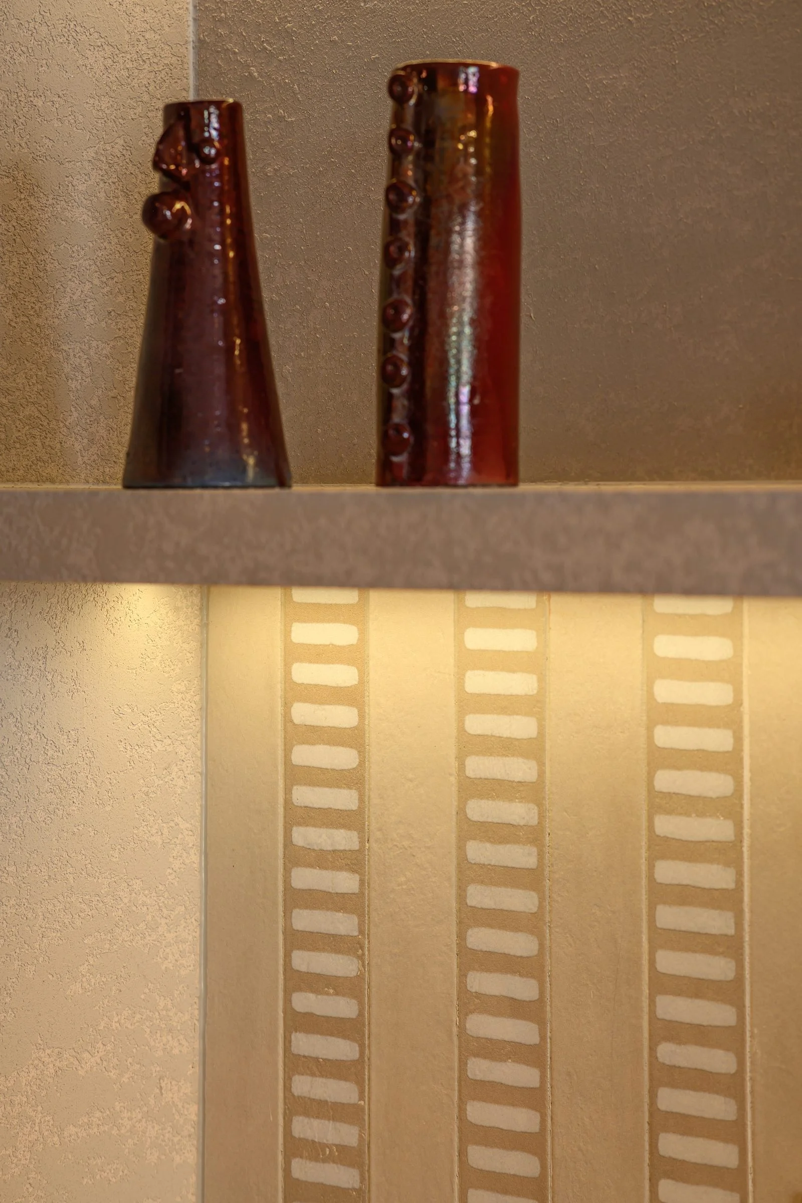 Casa Terrane — Ceramic vases on a lit plaster shelf