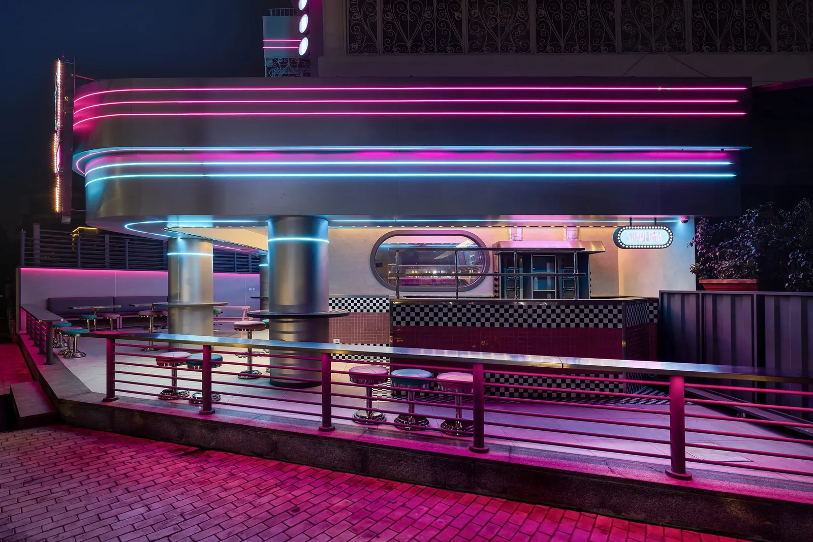 Pablo & Abdo — Exterior at night with pink and blue neon bands
