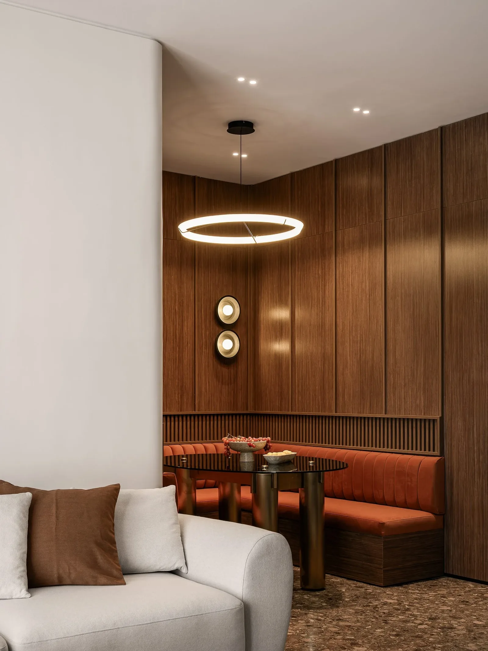 JW Marriott Residences — Dining nook in terracotta velvet beneath a halo pendant