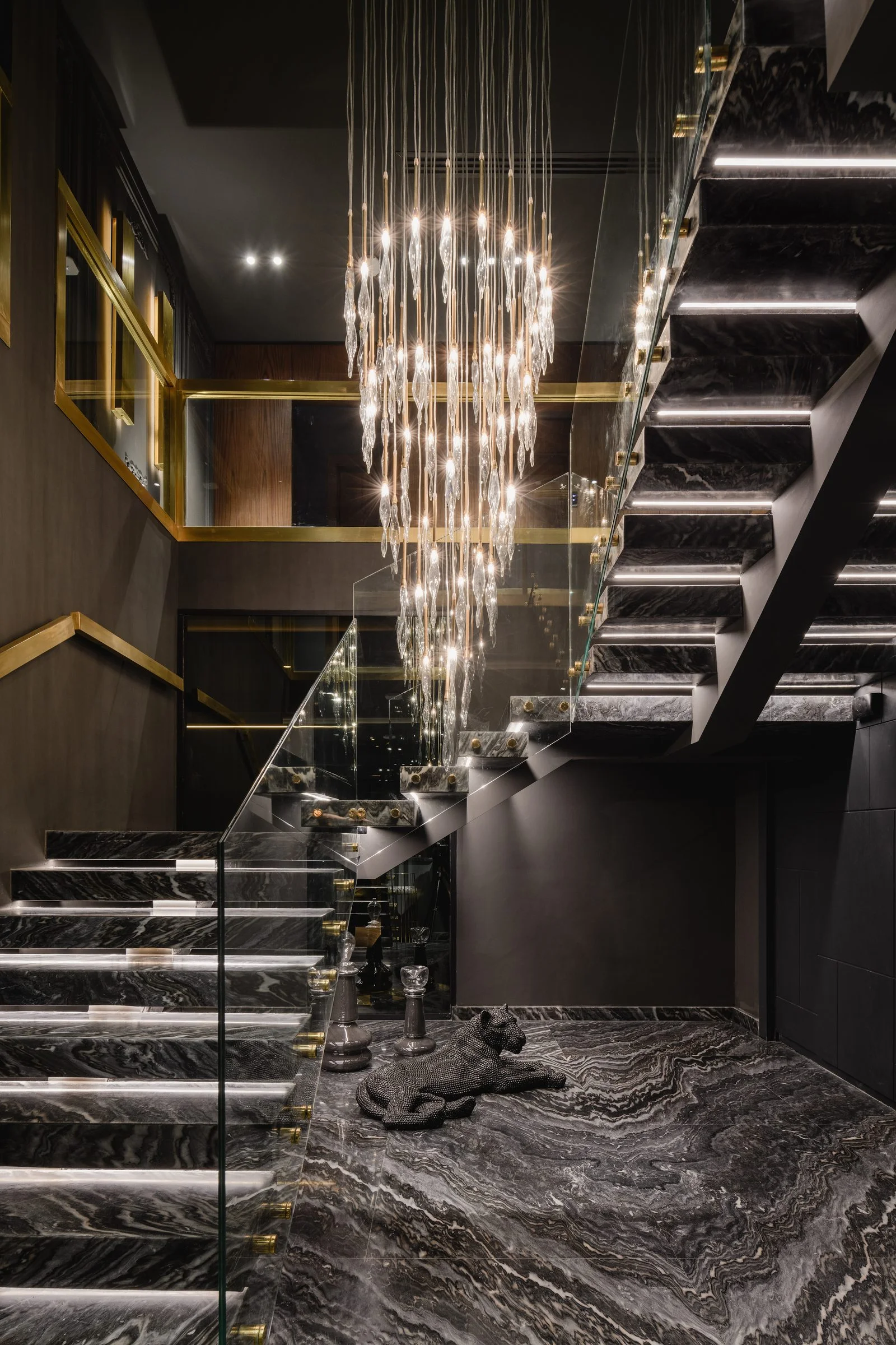 La Feuille Blanche — Staircase with a cascading crystal chandelier