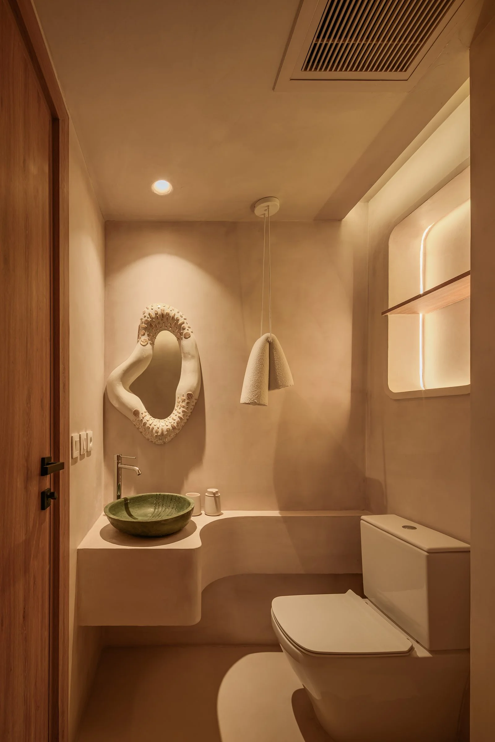 Casa Terrane — Powder room with a sculpted mirror